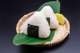 An image of Onigiri atop a bamboo plate